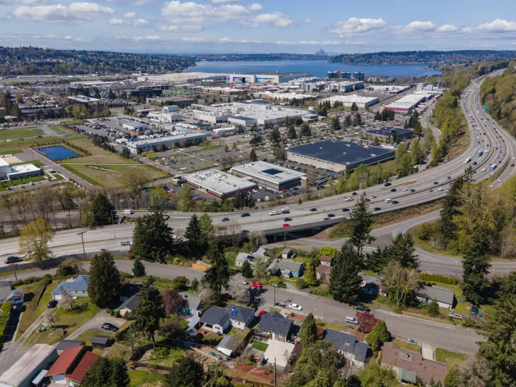 Aerial view of Renton, WA, with a residential area, highway, and Lake Washington under a partly cloudy sky