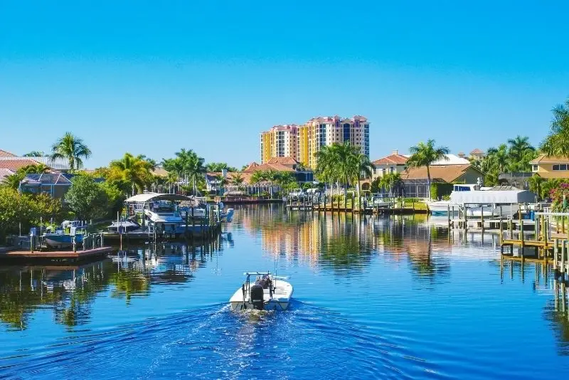 A peaceful Cape Coral canal with a boat moving through, showcasing waterfront living in Website Design and Development Cape Coral FL.