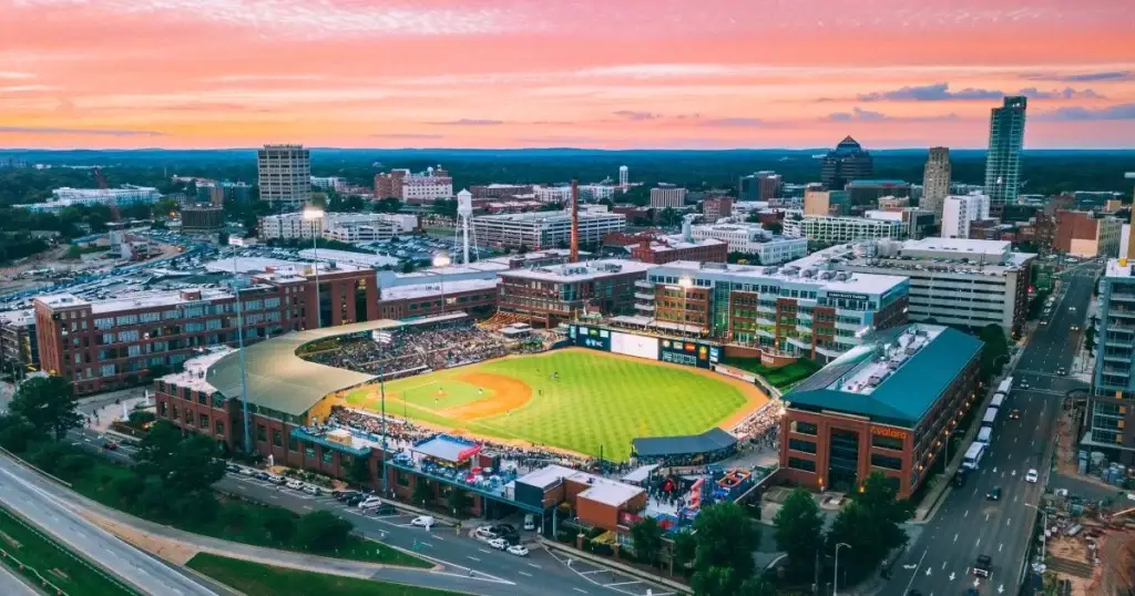 A stunning aerial view of Durham Bulls Athletic Park, with the vibrant downtown Durham skyline in the background, reflecting Website Design Durham NC.