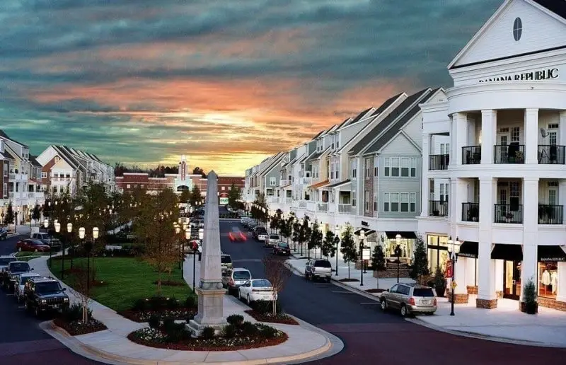 A stunning view of residential buildings and shops in Huntersville, NC with a vibrant sunset sky, highlighting Website Design Huntersville NC.