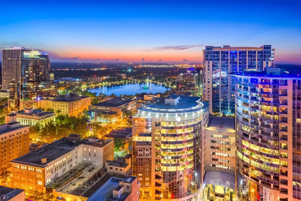 A vibrant night-time aerial view of downtown Orlando, with glowing city lights and the iconic Lake Eola, perfect for Website Design and Development Orlando FL.