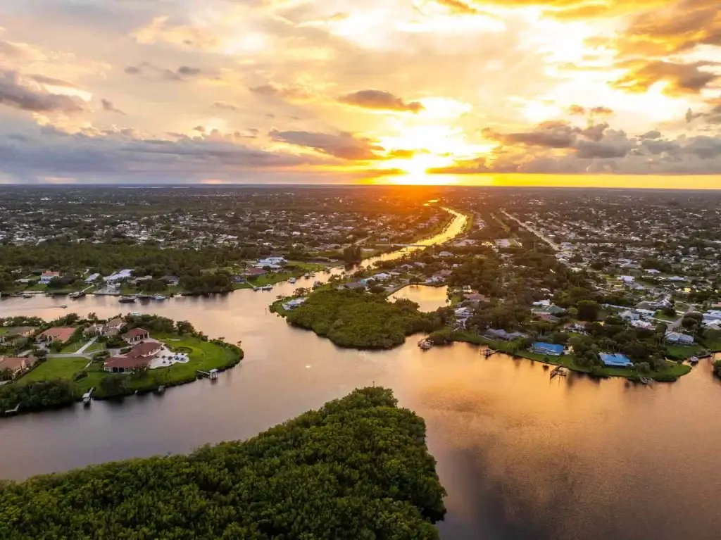 A breathtaking aerial view of Port St. Lucie with a river winding through homes at sunset, perfect for showcasing Website Design and Development Port St. Lucie FL.