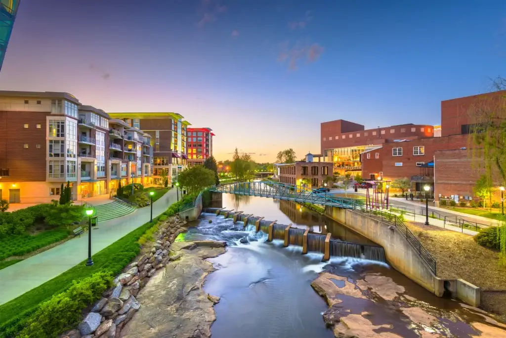 A beautiful shot of Greenville, NC, showcasing the waterfall, bridge, and vibrant downtown area, perfect for Website Design Greenville NC.