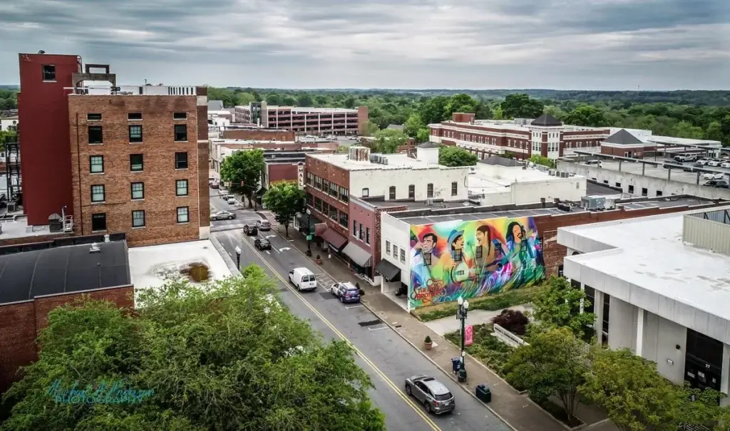 A colorful mural on a building in downtown Concord, NC, with surrounding trees and city streets, highlighting Website Design Concord NC