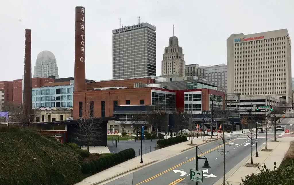 A view of Winston-Salem's skyline with R.J. Reynolds Tobacco smokestacks and modern buildings, reflecting Website Design Winston-Salem NC.