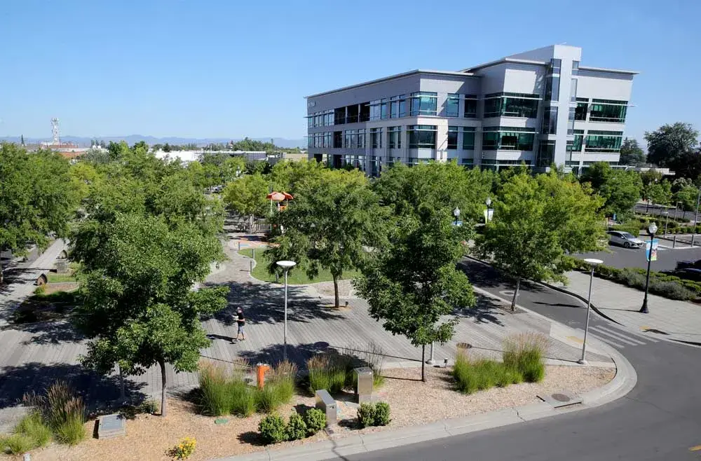 Contemporary park plaza in Medford, OR with trees, decking, and modern office building. Grow your reach with Website Design Medford OR.