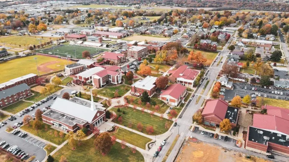 Wide aerial of the Campbellsville University campus with brick buildings and fall foliage, representing the robust local economy that relies on professional Website Design Campbellsville KY.
