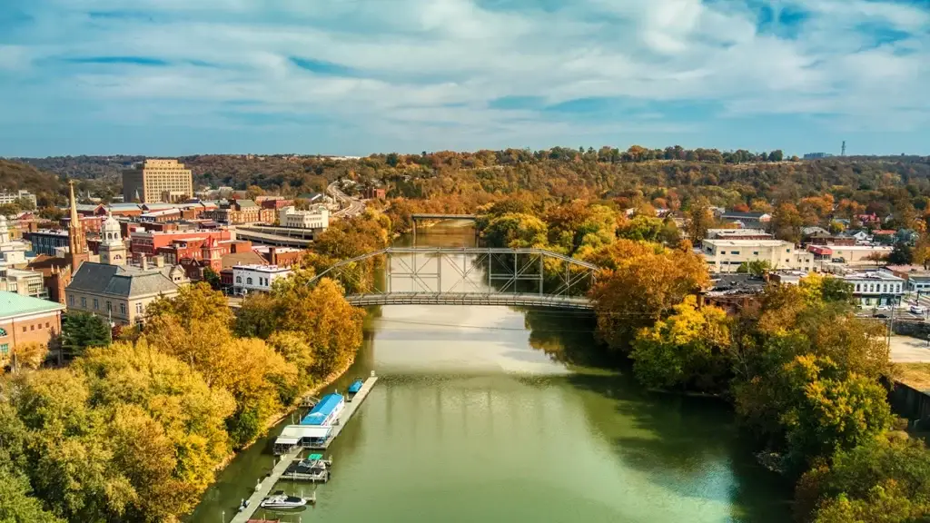 Aerial view of the Kentucky River flowing through Frankfort's downtown, framed by autumn trees and a metal bridge, showing the ideal location for excellent Website Design Frankfort KY.