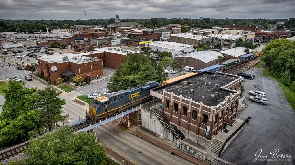 Downtown Madisonville, Kentucky, featuring a CSX train crossing a bridge over a street in an urban area, a busy location for businesses seeking premium Website Design Madisonville KY.