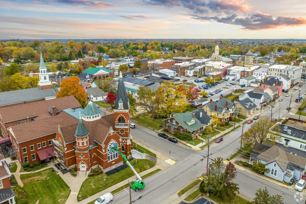 A high-angle view of a brick church with dark spires and surrounding residential and commercial areas in Georgetown, KY, a growing town that needs quality Website Design Georgetown KY.