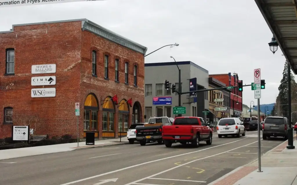 Downtown Forest Grove OR street corner with historic brick building, traffic, and commercial storefronts. Local market visibility is key with Website Design Forest Grove OR.