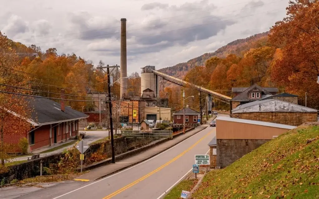 Autumn scene in Lynch, KY, showing a large industrial coal structure and smokestack beside a rural road, requiring modern Website Design Harlan KY.