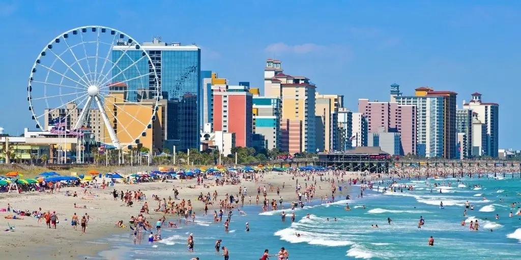 A vibrant view of Myrtle Beach SC with a Ferris wheel, beachgoers, and skyscrapers, ideal for Website Design Myrtle Beach SC.