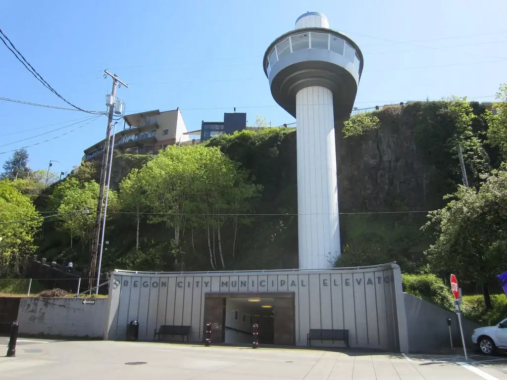 The historic Oregon City Municipal Elevator entrance at street level with its iconic tower rising up a cliff, under a clear sky. Tourism thrives with excellent Website Design Oregon City OR.